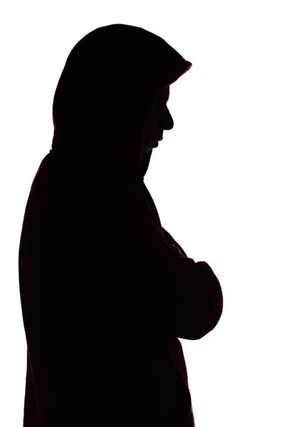 dark male silhouette in casual sportswear with a hood, figure of a guy hiding his face, concept of privacy and confidentiality