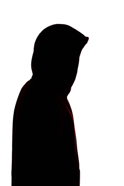 Silhouette maschile scura in abbigliamento sportivo casual con cappuccio, figura di un ragazzo che nasconde il suo volto, concetto di privacy e riservatezza — Foto Stock