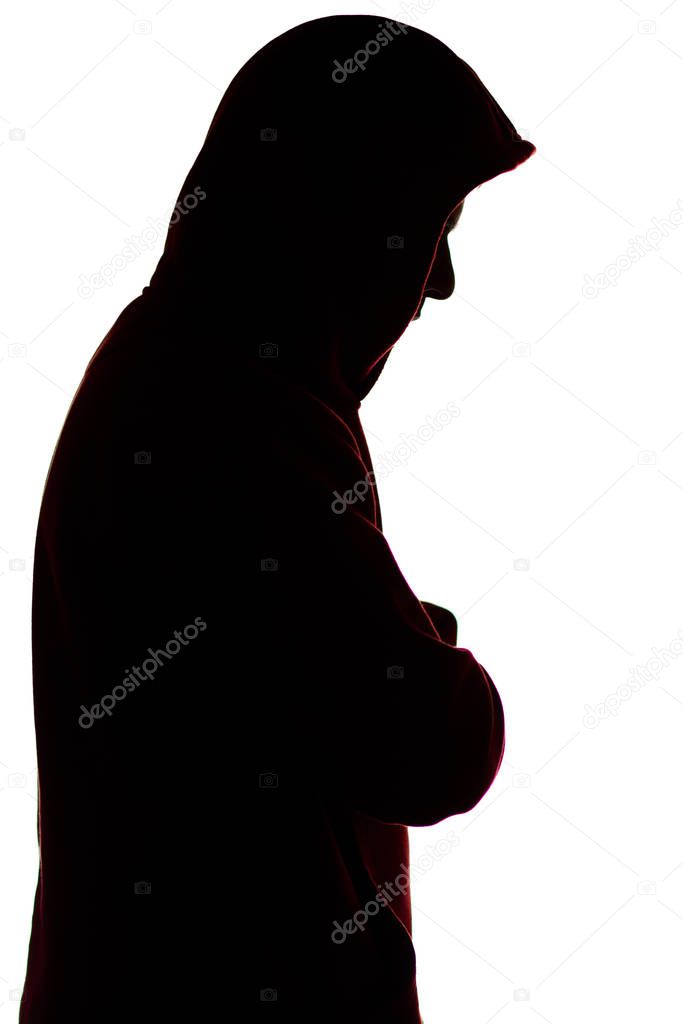 dark male silhouette in casual sportswear with a hood, figure of a guy hiding his face, concept of privacy and confidentiality