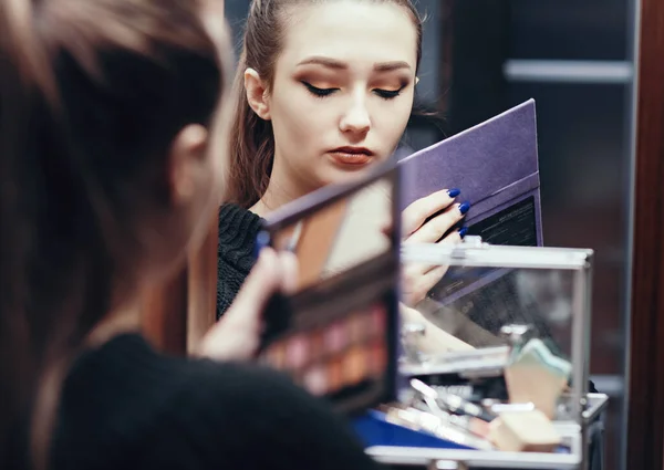 在房间的梳妆台上 镜子里的一个漂亮姑娘在化妆 年轻女子在准备着脸 女性的美感和化妆品 — 图库照片