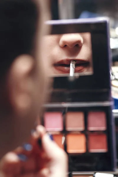 用唇膏在调色镜上反映女性唇的倒影 女孩在室内化妆 画出轮廓 美的概念和化妆品 — 图库照片