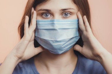 Genç adam salgın haberleri yüzünden şoka girdi. Stüdyonun arka planında koruyucu maske takan bir kız. Korkmuş, sağlık tehlikesi kavramı.