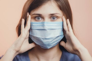 Genç adam salgın haberleri yüzünden şoka girdi. Stüdyonun arka planında koruyucu maske takan bir kız. Korkmuş, sağlık tehlikesi kavramı.