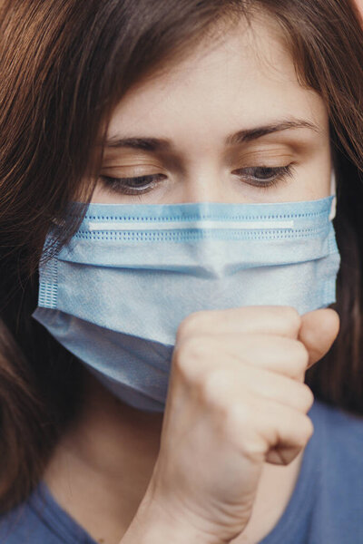 sick woman in medical mask coughing on studio background, concept of prevention viral deseases, person with breathing problems