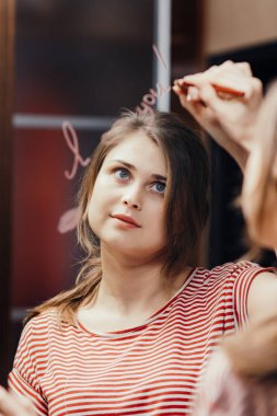 Kozmetik kalemle yazılmış genç bir kadının aynada 