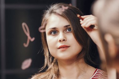 Genç bir kadının, seni aynada, insan psikolojisi ve kendini tedavi etme konseptinde sevdiğini doğrulayan sözler yazmasının yansıması.