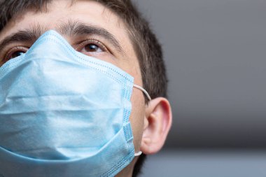 Hastane koğuşunda ameliyata hazır cerrahi maske takan doktor şefi. Kendine güveni, sağlık ve tıp anlayışı ile bakan bir adam.