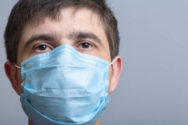 Koruyucu maskeli genç doktorun başı umut ve güvenle bakıyor, tıp ve sağlık kavramı