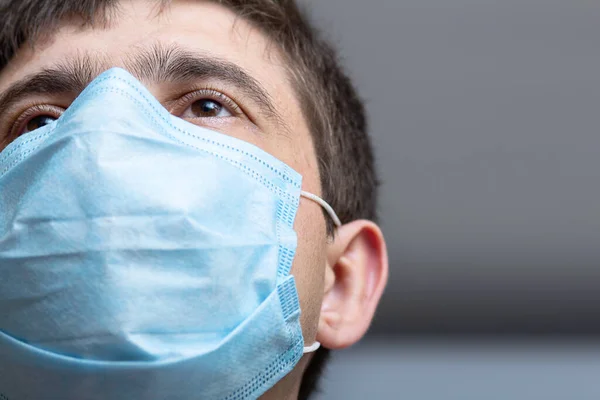 head of doctor in surgical mask ready to operate in hospital ward, man looking straight with confidence, concept of medicine and health, bottom view