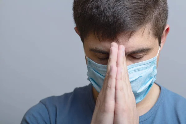 Młody Człowiek Ochronnej Masce Medycznej Pochylił Głowę Rozpaczy Modlił Się — Zdjęcie stockowe
