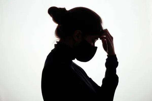 Silhouette of the girl face profile of an unrecognizable sad, woman in  depression put her hand to forehead Stock Photo by ©fantom_rd 168699036