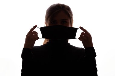 Beyaz arka plan, karantina önlemleri ve hayat kurtaran konsept üzerinde açık koruyucu maske gösteren genç kadın silueti