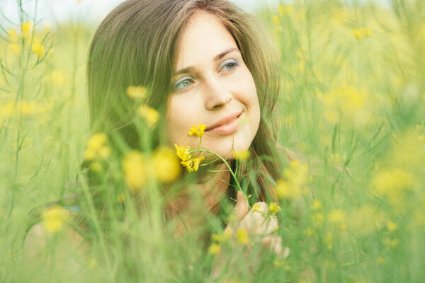 beautiful romantic girl on blooming rapeseed field enjoying nature, young elegant woman walking,pretty female face, concept happiness , freedom, inspiration