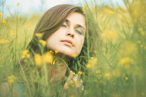 beautiful romantic girl on blooming rapeseed field enjoying nature, young elegant woman walking,pretty female face, concept happiness , freedom, inspiration