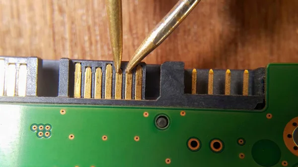 Radyo teknisyeni bilgisayarın bir bölümünü onarıp dijital çokölçer, makro fotoğrafçılık ve kontaklar üzerine seçici odaklanma kullanarak ölçümler yapıyor.