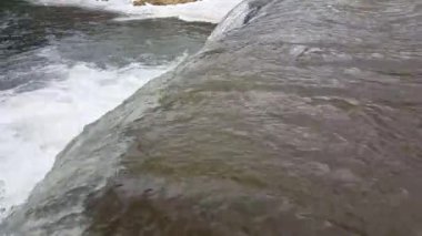 Kış mevsiminde küçük bir dağ nehri, soğuk buzulların olduğu, güzel bir kış manzarası..