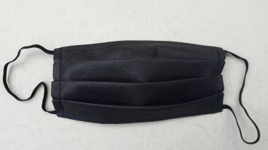 Gümüş arka planda siyah yüz maskesi. Koronavirüse karşı hava damlacıkları tarafından korunmak için tıbbi malzeme. düz yatay foto.