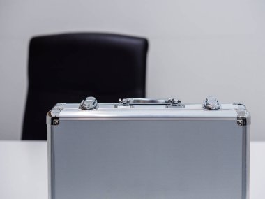 Ofis ortamında masanın üzerindeki metal bir çantayı kapat.