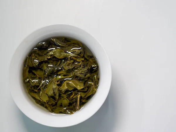 Plana vista lay de chá verde chinês oolong fabricado em uma xícara de porcelana — Fotografia de Stock