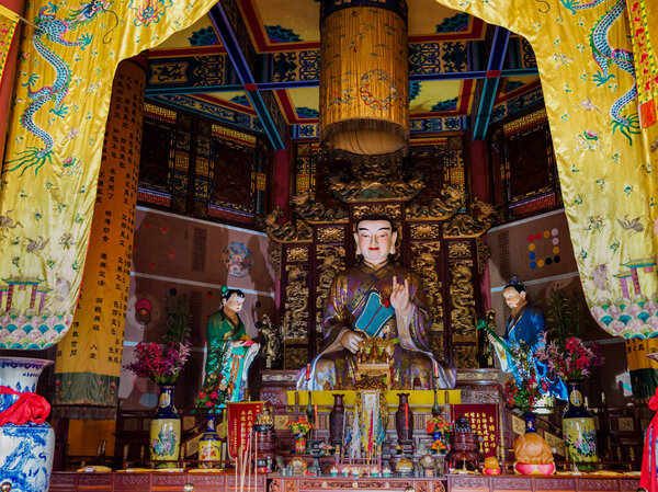 Elaborately carved and decorated statue of Buddha at a Taoist te