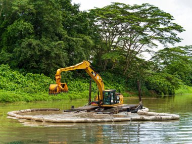Bir kazıcı / buldozer kanalda tarama yapıyor.
