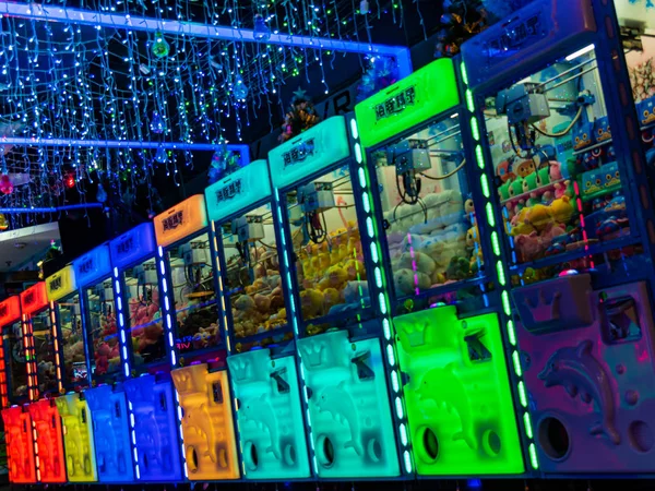 Monety obsługiwane maszyny żuraw pazur w jasnych kolorach neon i pełne Obraz Stockowy