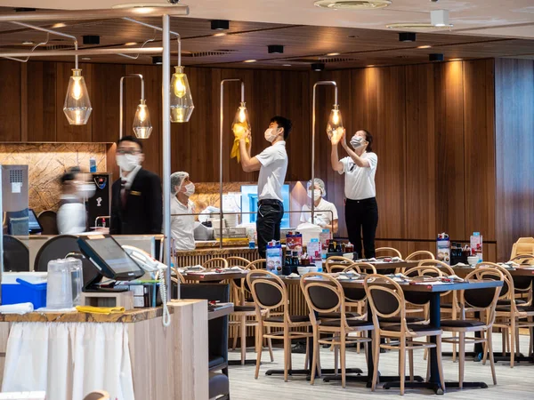 Ding Tai Fung Çin Lokantası personeli maske takarken temizlik / dezenfekte etme / dezenfekte etme yöntemini uyguluyor. Restoran Breadtalk grubu tarafından işletiliyor.