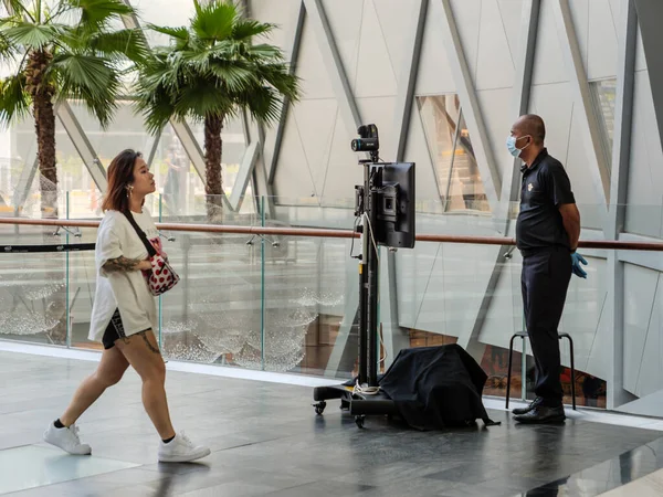 SINGAPORE 23 MAR 2020 Asyalı kadın Jewel Mall, Singapur Havaalanı 'nda termal kamera tarayıcısı / sıcaklık tarayıcısının yanından geçiyor. Kamera Corona virüsü / manastır 19 taşıyıcılarında ateş tespit etti.
