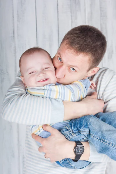 Father Hugs Kisses His Little Son Boy Smiles Indoor Photo — Stock Photo, Image