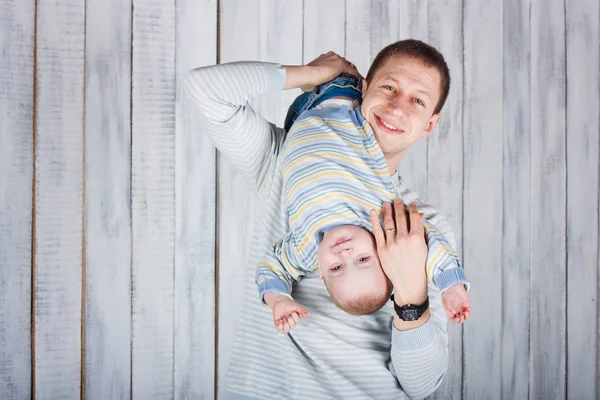 Father Plays His Little Son Boy Hungs Upside Indoor Photo — Stock Photo, Image