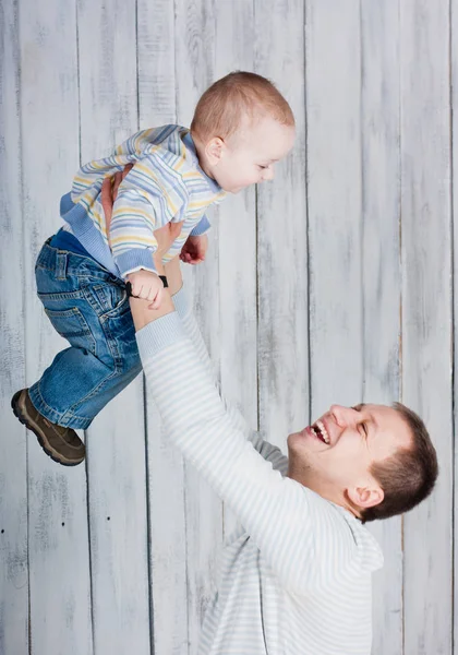 Vater Wirft Seinen Kleinen Glücklichen Sohn Die Luft Indoor Fotoshooting — Stockfoto