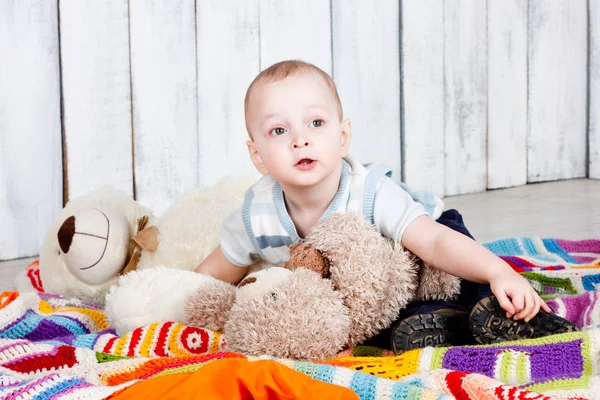 小男孩躺在地板上 毛毯上的玩具五彩斑斓 室内摄影 — 图库照片