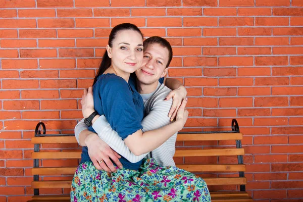 若いカップル抱擁し ベンチに座っている 室内写真撮影 — ストック写真