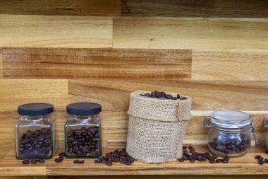 Kahve çekirdekli şeffaf kavanozlar. Sıraya dizilmiş çeşitli kahve kutularının yakın plan çekimleri. Kahve dükkanı konsepti