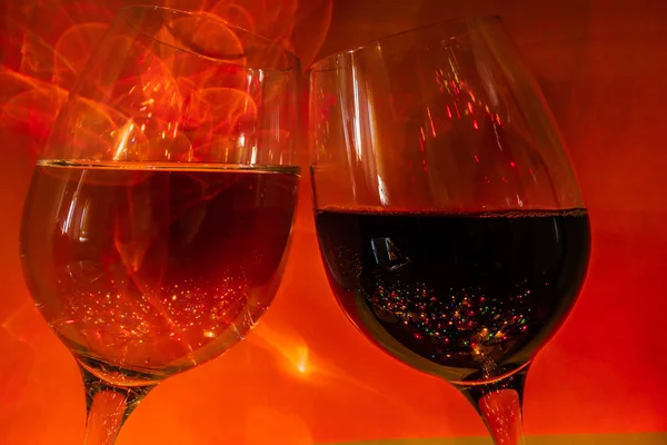 a glass of champagne and a glass of wine on a dark orange background