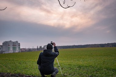 Adam sahada gökyüzünü fotoğraflıyor.