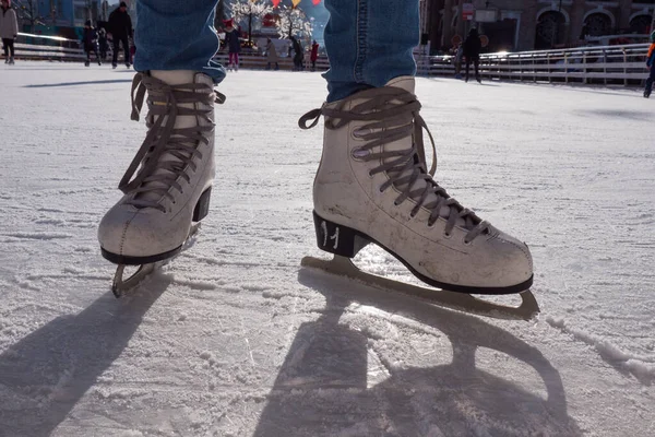 Pies en patines. Pista pública de patinaje sobre hielo, par de patines, hielo rayado, día soleado en invierno. Patinaje de chicas en pista de hielo. Fotografía de cerca. Foto de alta calidad — Foto de Stock