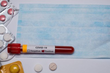 Koronavirüs için kan testi pozitif çıktı. Tıbbi müdahale, kan testi tüpü, tıbbi maske, haplar. Coronavirüs salgını ve grip. 2019-ncov, covid-19, sars. Yüksek kalite fotoğraf. 