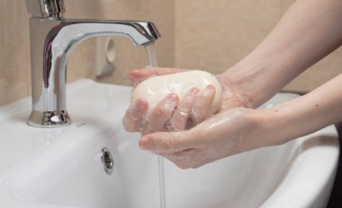 Hijyen. Temizlikçi Eller. Ellerimi sabunla yıkıyorum. Beyaz sabun ve köpüklü kadın eli. Koronavirüsten kendinizi koruyun COVID-19 pandemisi.