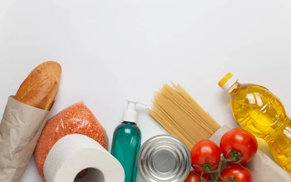 Yemek dağıtım servisi. Karantina sırasında internetten ürün alın. Beyaz arka planda sağlıklı yiyecek ve antiseptik. Ayçiçeği yağı, domates, makarna, ekmek, mercimek, konserve yiyecek, tuvalet kağıdı, dezenfektan.