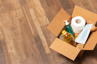 Bağış malları yerdeki karton kutuda. Makarna, tuvalet kağıdı, tıbbi maske, ayçiçeği yağı, dezenfektan, konserve yiyecek, ekmek. İhtiyacı olanlar için yemek..