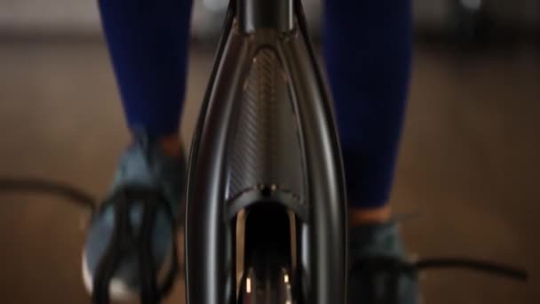 現代の暗いジムで運動器具を使用して運動の女の子 自転車のペダルのフィットネス ペダルの上の女性の足を閉じる 健康的なライフスタイルとスポーツの概念 サイクル中の女性 — ストック動画