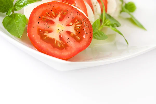 Salada Caprese com queijo mussarela, tomate e manjericão isolados sobre fundo branco — Fotografia de Stock