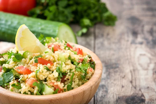Tabbouleh salad with couscous on rustic table — Stock Photo, Image