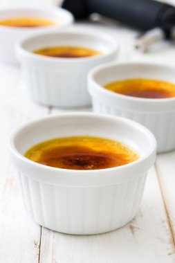 Geleneksel Fransız Creme brulee tatlısı üstte, ahşap masa karamelize şeker