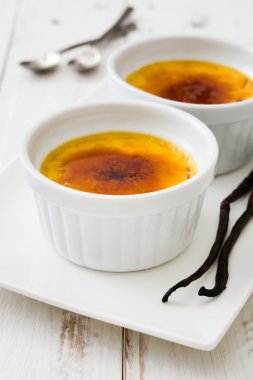 Geleneksel Fransız Creme brulee tatlısı üstte, ahşap masa karamelize şeker