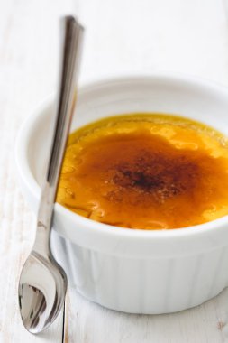 Geleneksel Fransız Creme brulee tatlısı üstte, ahşap masa karamelize şeker