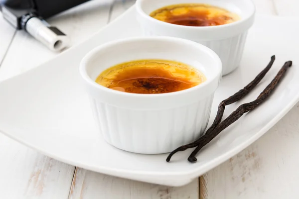 Tradycyjny francuski crème brulee deser z karmelizowanego cukru na górze, na drewnianym stole — Zdjęcie stockowe
