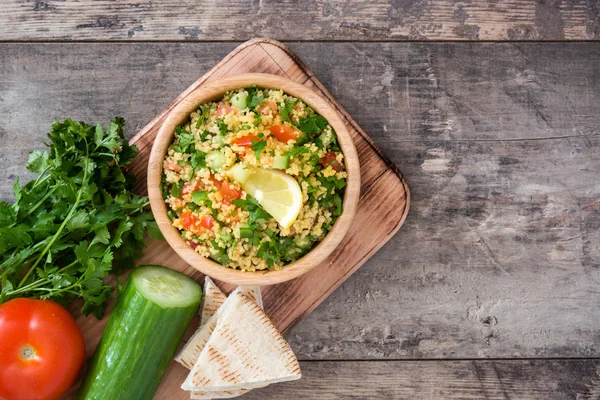 Ensalada Tabbouleh con cuscús sobre mesa rústica — Foto de Stock