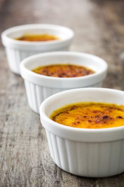 Geleneksel Fransız Creme brulee tatlısı üstte, ahşap masa karamelize şeker